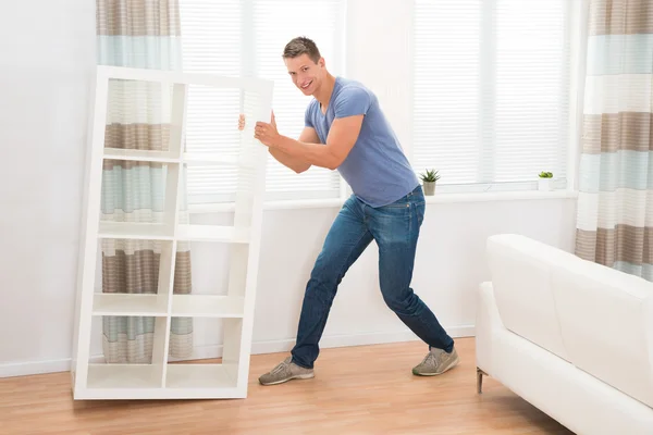 Young Man Moving Shelf — Stock Photo, Image