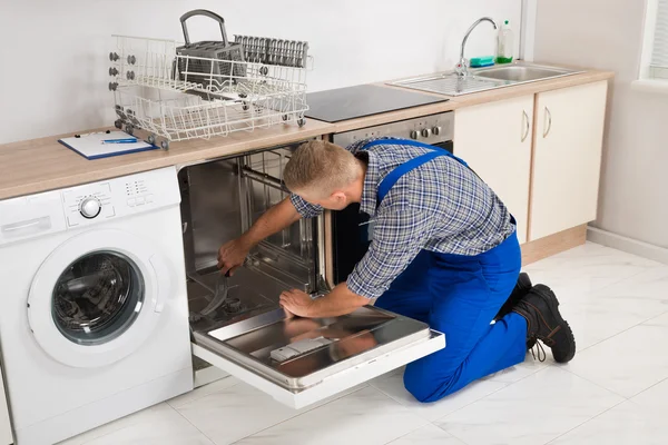 Reparador fixando máquina de lavar louça — Fotografia de Stock