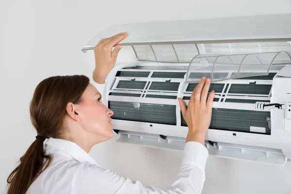 Affärskvinna kontrollera Air Conditioner — Stockfoto