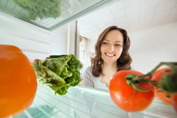 Vrouw kijken naar groenten — Stockfoto