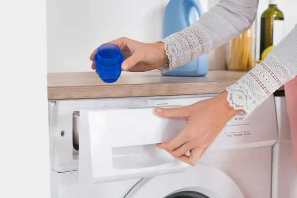 Las manos femeninas vierten detergente en la lavadora —  Fotos de Stock