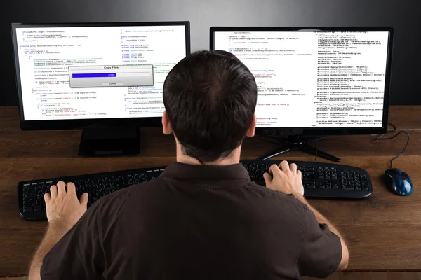 Mann programmiert Code auf Computern — Stockfoto