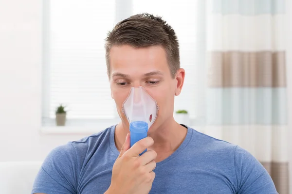 Hombre inhalando a través de máscara de inhalador — Foto de Stock