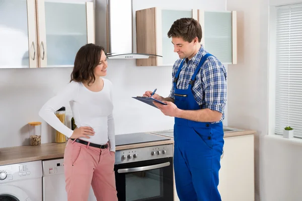 Mujer y reparador en cocina — Foto de Stock