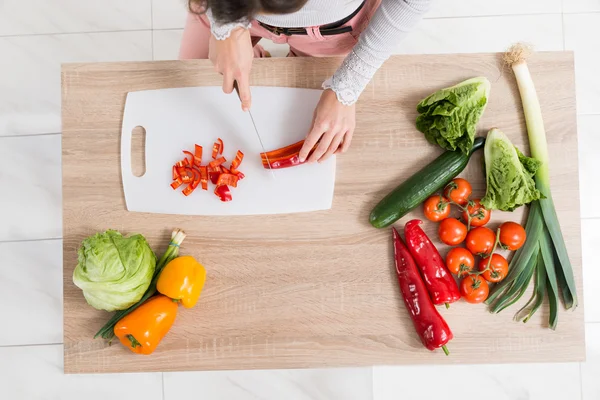 Femme hachant des légumes avec couteau — Photo