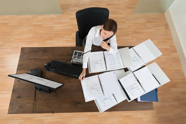 Zakenvrouw oproep terwijl berekening van Financiën bijwonen — Stockfoto