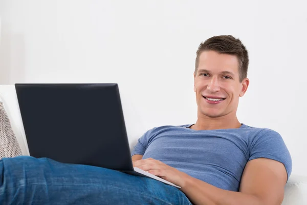 Homem usando laptop na sala de estar — Fotografia de Stock
