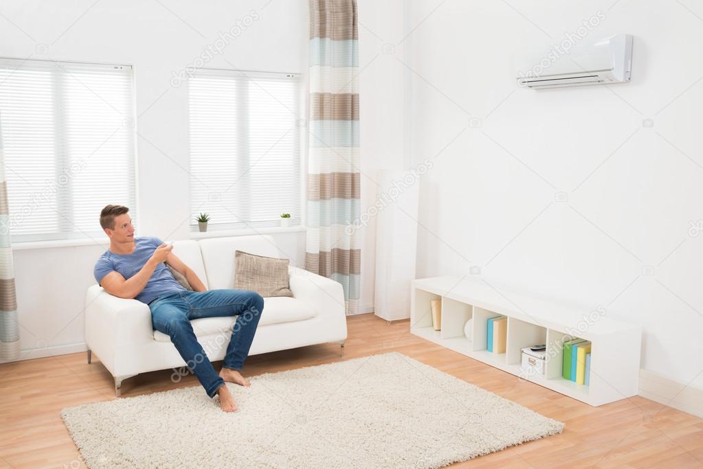 Young Man Operating Air Conditioner