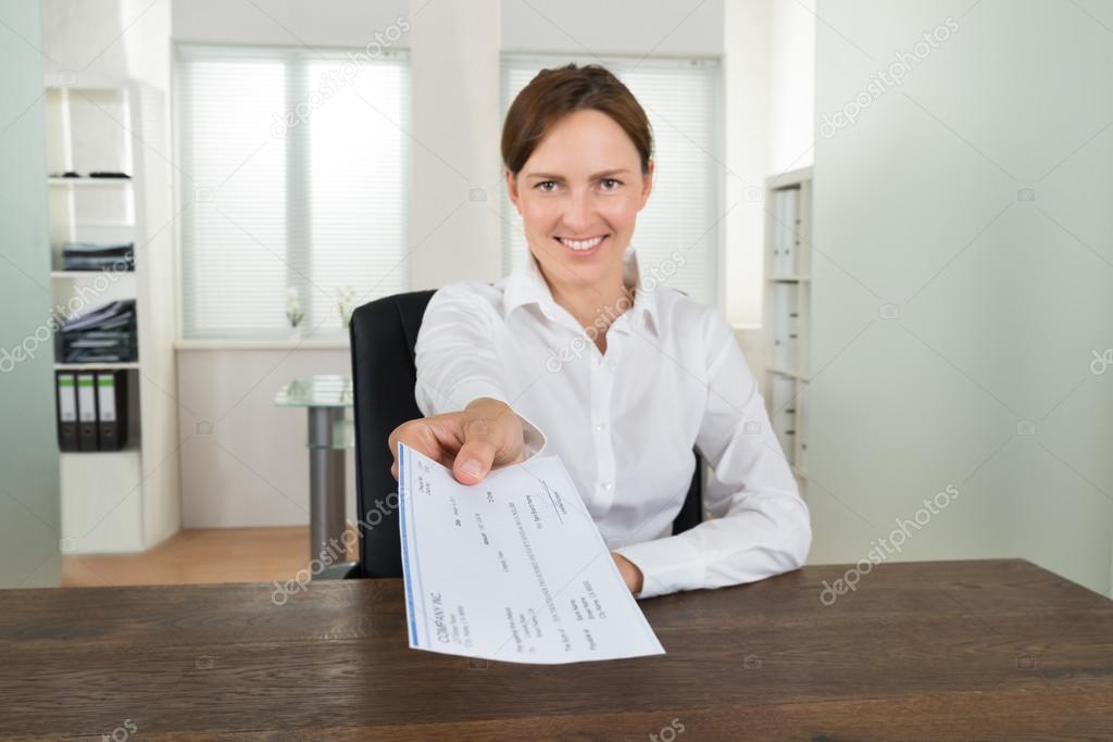 Businesswoman Offering Cheque In Office