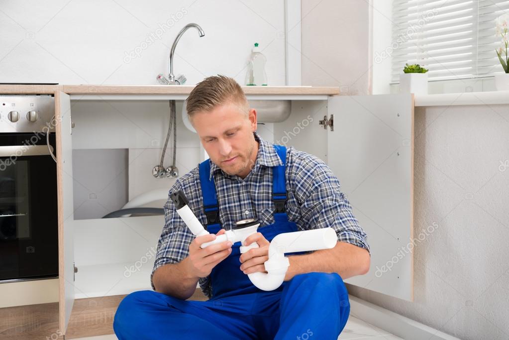 Plumber With Pipe In Kitchen Room