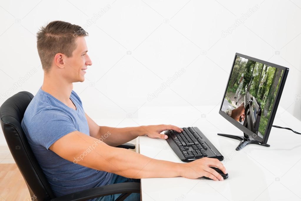 Man Playing Game On Desktop Computer — Stock Photo © AndreyPopov 82921610