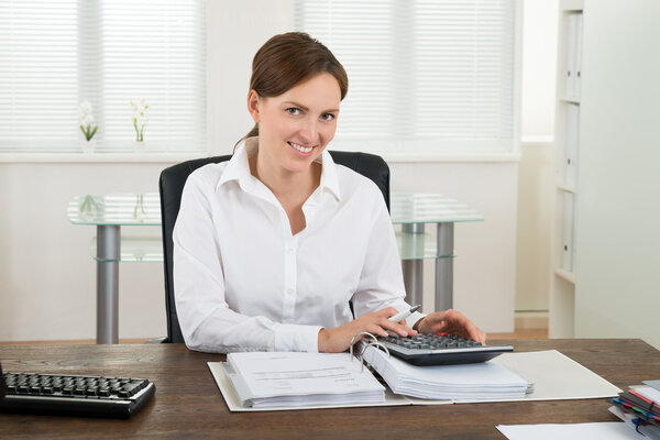 Businesswoman Calculating Invoice