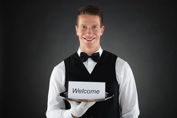 Camarero Holding Bienvenido en la tarjeta — Foto de Stock