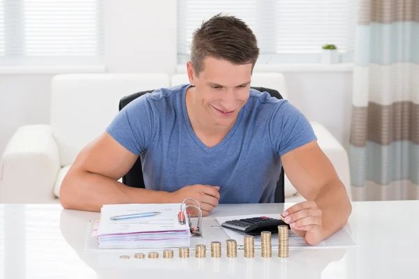 Hombre calculando factura con monedas —  Fotos de Stock