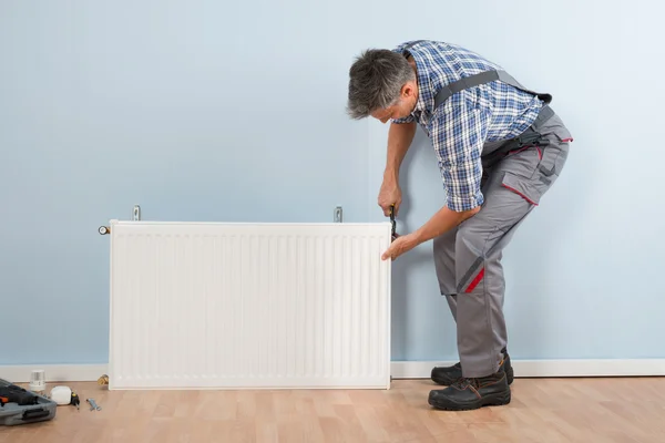 Mannelijke loodgieter vaststelling Radiator — Stockfoto