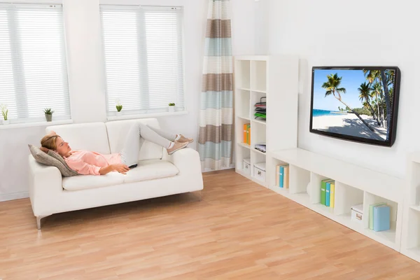 Mujer joven viendo la televisión — Foto de Stock