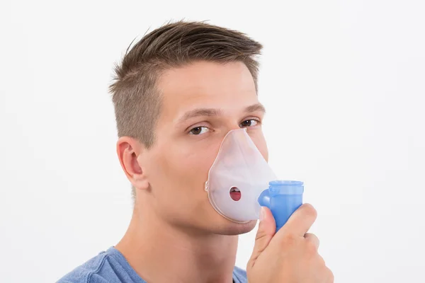 Человек, вдыхающий через маску ингалятора — стоковое фото