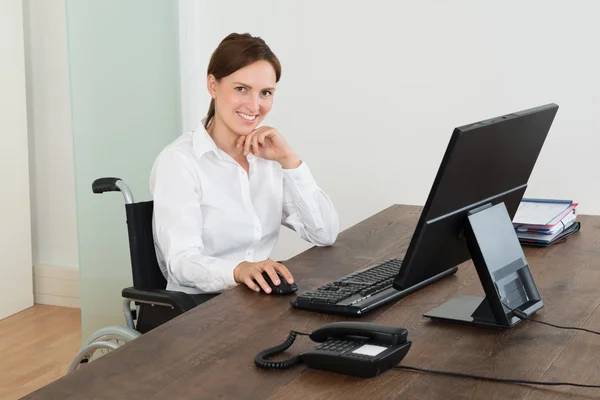 Empresária em cadeira de rodas enquanto trabalhava no computador — Fotografia de Stock