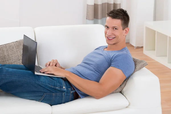 Homme utilisant un ordinateur portable dans le salon — Photo