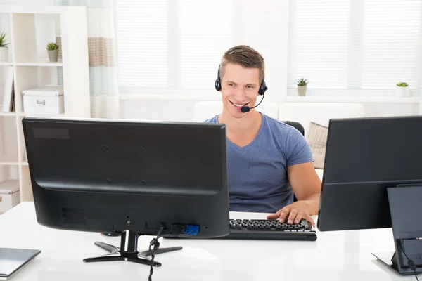 Bilgisayarda kulaklık ile konuşan adam — Stok fotoğraf