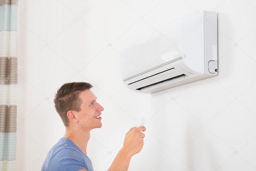 Man With Remote Control of  Air Conditioner