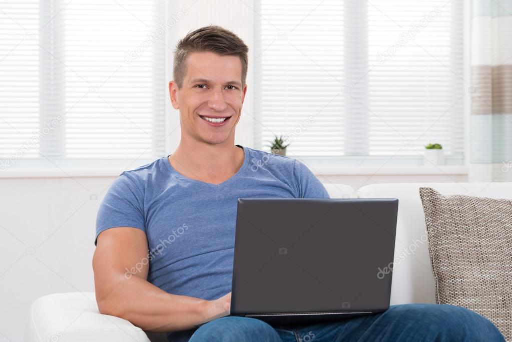 Man On Sofa Using Laptop