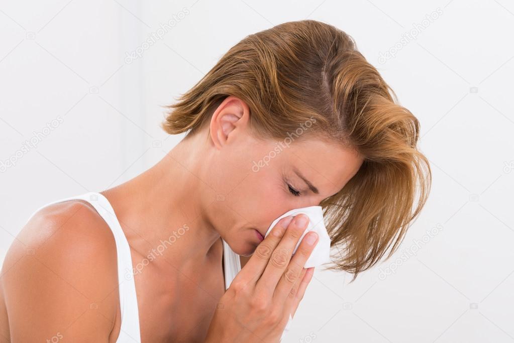 Woman Blowing Nose In Tissue Paper