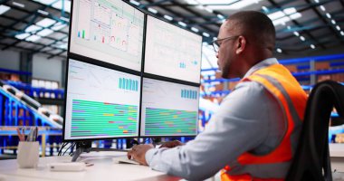 Siyah Afro-Amerikalı Adam Endüstriyel Depo 'da Bilgisayar Hesap Tabloları Çalışıyor