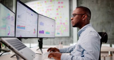 Odaklanmış Afrikalı Amerikalı Adam Laptop ekranında Mali Verileri Analiz Ediyor.