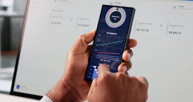 İş Adamı Cep Telefonundaki Öngörücü Analitik Kontrol Panelini kullanarak Piyasa Eğilimlerini Analiz Ediyor.