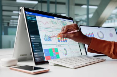 Tablet ekranındaki veri analiz ediliyor, bir kadın analist özenle çalışıyor.