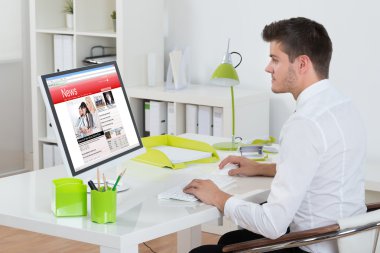 Bilgisayarda online haber izlerken işadamı