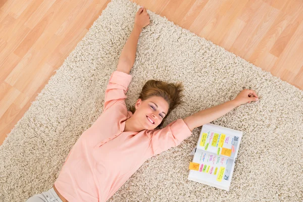 Vrouw met dagboek liggen op tapijt — Stockfoto