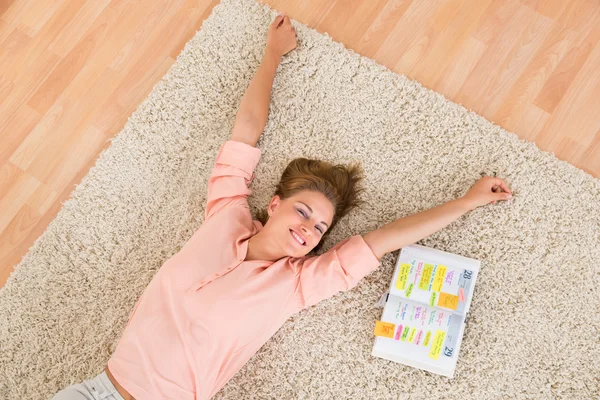 Mujer con diario acostada en la alfombra — Foto de Stock