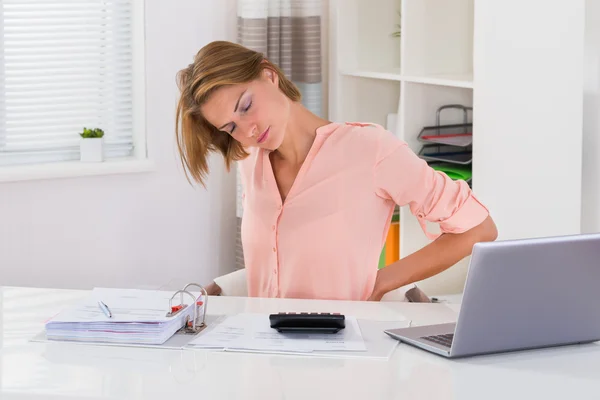 Jonge vrouw die lijdt aan rugpijn — Stockfoto