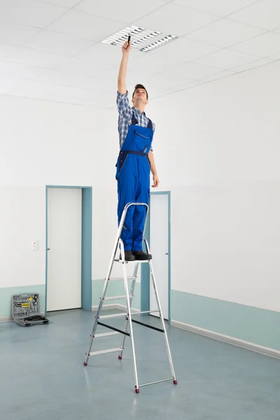 Elektricien installeert plafondlamp — Stockfoto