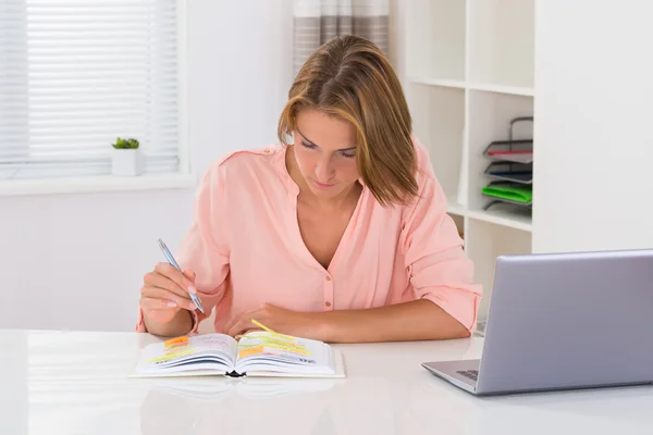 Vrouw schrijven schema In dagboek Rechtenvrije Stockafbeeldingen