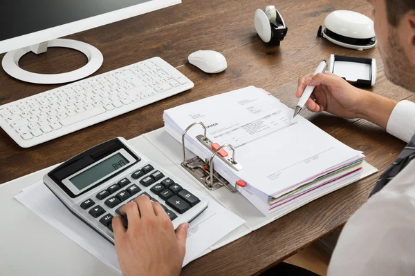 Fatura de verificação do homem de negócios com calculadora — Fotografia de Stock