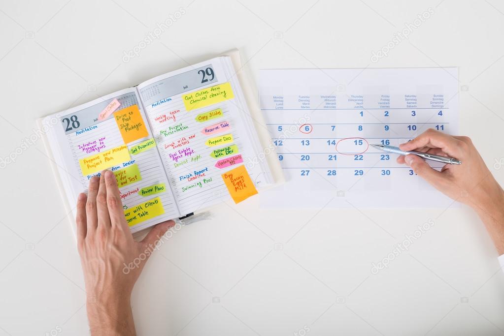 Person Hands Highlighting Date On Calendar