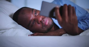 Gece yarısı alem yapan Afrikalı Adam Yatakta Telefona Yapışmış Bu Fotoğrafta, Afrikalı Adam Nişanlı