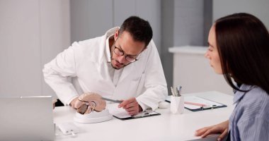 Klinikteki nörolog mutlu kadın hastaya beyin modelini gösterdi.