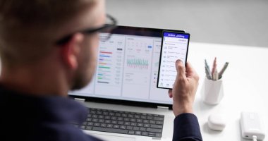 Genç adam internet bütçesi ve finansmanı yönetmek için akıllı telefon uygulamasını kullanıyor. Muhtemel Meslekler: Muhasebeci