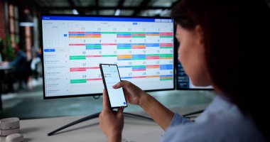 Masadaki Akıllı Telefon 'da Takvim ve E- posta Yöneticisi Meşgul Kadın.