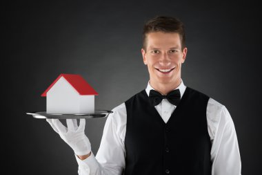 Ev modeli ile tepsi tutarak Butler