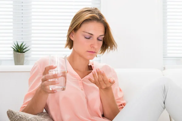 Femme avec médecine et verre d'eau — Photo