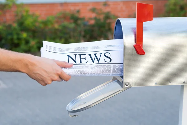 Mãos de pessoa abrindo caixa de correio para remover jornal — Fotografia de Stock