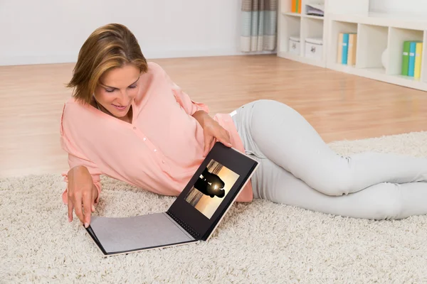 Mujer mirando álbum de fotos — Foto de Stock