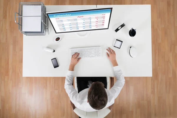 Jonge zakenman kalender kijken op Computer — Stockfoto