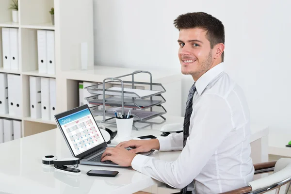 Empresario mirando el calendario en el ordenador portátil — Foto de Stock