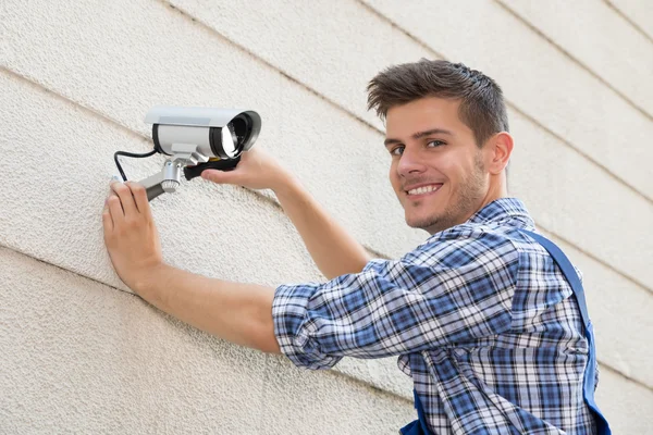 Techniker befestigt Videokamera an Wand — Stockfoto